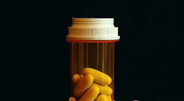 Prescription pill bottle with yellow capsules